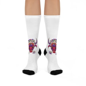 Puede incluir: Calcetines blancos con un diseño de cabeza de toro colorido con un tercer ojo y una corona de setas.