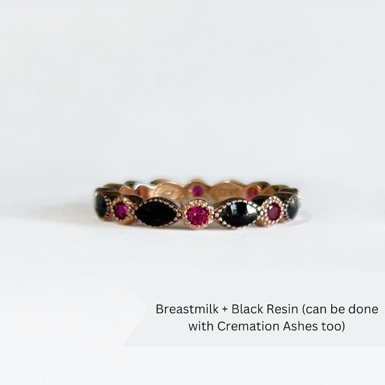 May include: A gold band ring with black resin and pink gemstones. Breastmilk + Black Resin (can be done with Cremation Ashes too)