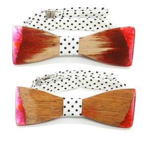 Può includere: Due papillon in legno con intarsi in resina rosa e rossa. I papillon hanno un cinturino regolabile a pois bianchi e neri.