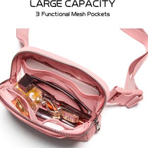 May include: A pink fanny pack with a zipper closure and adjustable strap. The bag is open, revealing three mesh pockets filled with items like a phone, glasses, and cosmetics. Text at the top reads "LARGE CAPACITY" and "3 Functional Mesh Pockets."