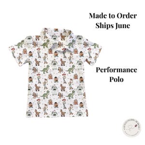 May include: White performance polo shirt with a pattern of cartoon characters. The shirt has a collared neckline and short sleeves. The text "Made to Order Ships June" and "Performance Polo" are visible.