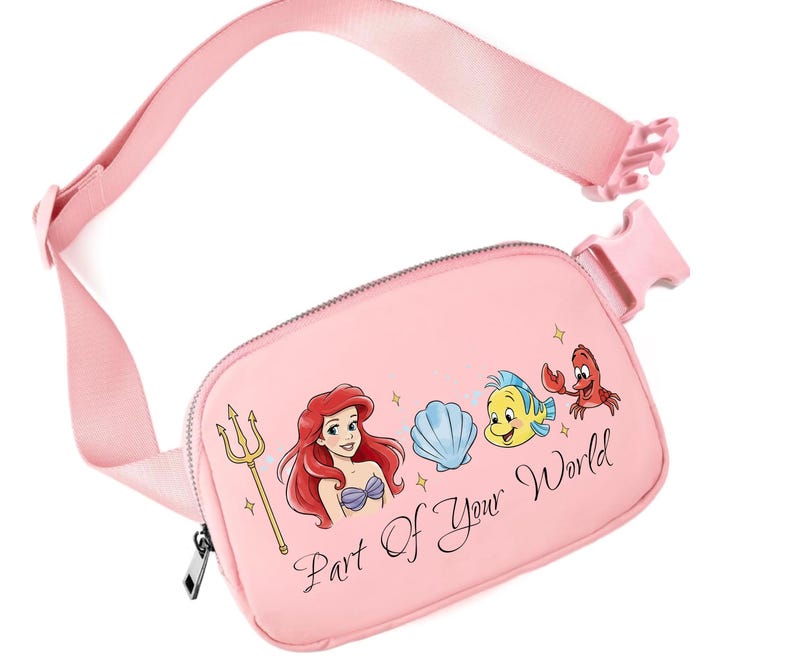May include: Pink fanny pack with a graphic of Ariel, Flounder, Sebastian, and a seashell. The text "Part Of Your World" is printed on the front. It has a zip closure and an adjustable strap.