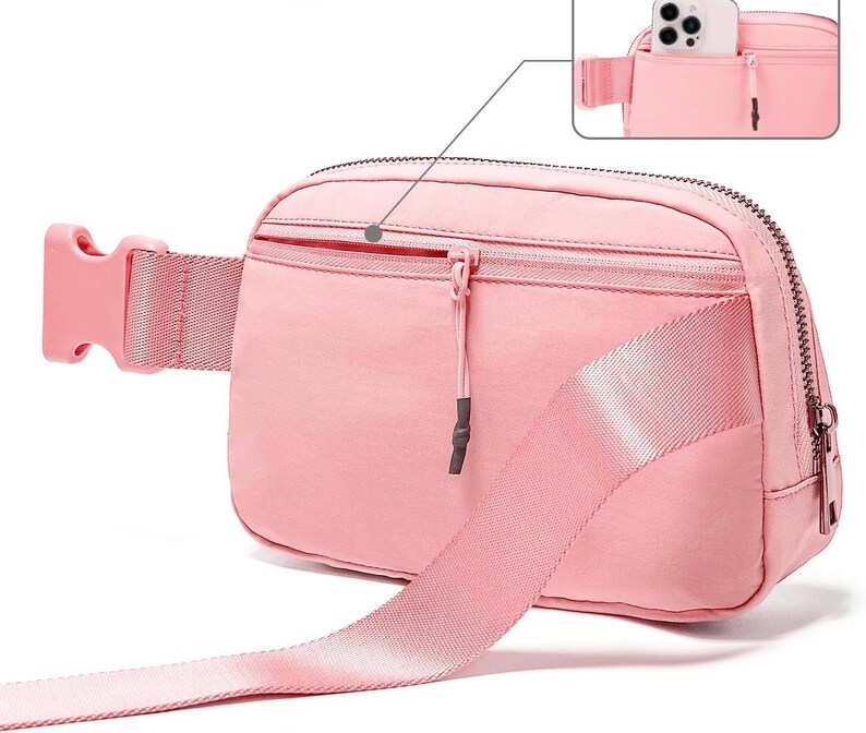 May include: A pink fanny pack with a zippered main compartment and a smaller front pocket. The adjustable strap and buckle are also pink. A close-up shows a phone in the back pocket. The bag is made of a smooth, durable material.