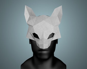 May include: A grey paper mask shaped like a fox head. The mask has a geometric design and is made of folded paper.