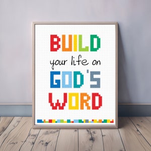 May include: A framed cross-stitch design with the words "BUILD your life on GOD'S WORD" in colorful block letters. The letters are made to look like colorful building blocks.