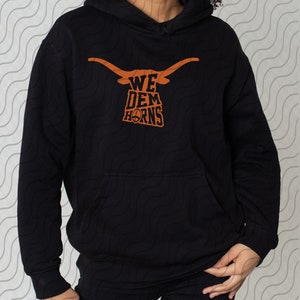 May include: Black hoodie with an orange graphic of a longhorn steer head with the text "WE DEM HORNS".