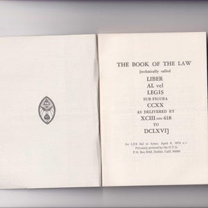 May include: A book titled "The Book of the Law" with the subtitle "[technically called Liber AL vel Legis Sub Figura CCXX As Delivered by XCIII=418 to DCLXVI]" and the text "An LXX in Aries. April 9, 19... Privately printed by the O.T.O. P.O. Box 2041, Dublin, Calif. 94566".