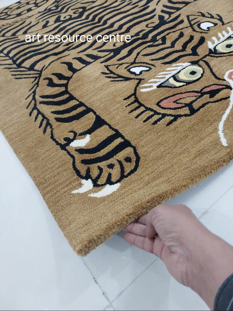 May include: A brown rug with a black and white tiger design. The tiger's face is visible, with black stripes and white accents. The rug has a fringe border.