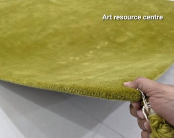 Puede incluir: Una alfombra de color verde chartreuse sólido con una textura densa de pelo corto. La alfombra presenta un borde acabado y rematado, e incluye el texto "Art resource centre" impreso en blanco en la esquina superior derecha.