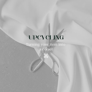 Puede incluir: Un par de tijeras plateadas están cortando una tela blanca con el texto "UPCYCLING Turning your item into a corset" en la parte superior de la tela.