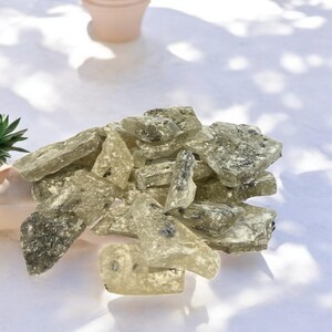 Pu&ograve; includere: Un mucchio di caramelle dure traslucide verdi e bianche con una consistenza granulosa.