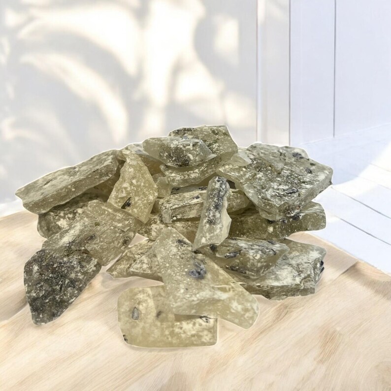 Pu&ograve; includere: Un mucchio di caramelle dure traslucide di colore verde chiaro con macchie scure in tutto. Le caramelle sono rotte in forme e dimensioni irregolari.