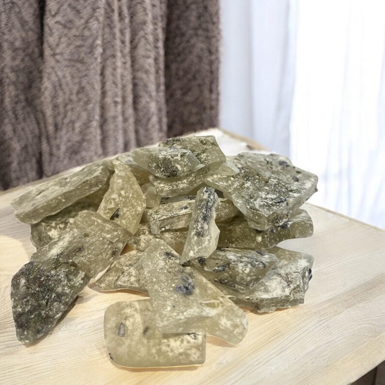 Pu&ograve; includere: Un mucchio di caramelle dure traslucide verdi e bianche con un aspetto maculato. Le caramelle sono rotte in forme e dimensioni irregolari.