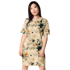 以下が含まれることがあります： 花柄と音符のプリントが施されたベージュのTシャツワンピース。袖は短めで、クルーネックです。