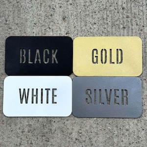 four rectangular metal plates, each with a different color and text, arranged in a square formation.