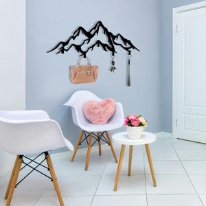Metal wall hook shaped like mountain range with jacket