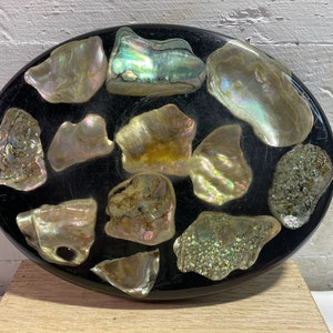 May include: Oval-shaped black tray with iridescent shell pieces embedded in the surface.