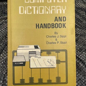 Peut inclure: Un livre jaune intitulé "COMPUTER DICTIONARY AND HANDBOOK" par Charles J. Sippl & Charles P. Sippl. La couverture présente un ordinateur vintage, une carte perforée et un boulier.