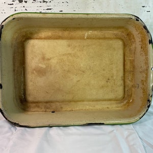 Puede incluir: Un molde para hornear rectangular de esmalte verde y crema vintage. El molde tiene un aspecto ligeramente desgastado, con algo de decoloración en el esmalte crema.