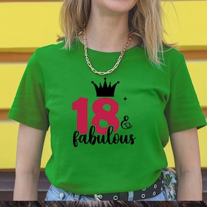 以下が含まれることがあります： 緑色のTシャツに、ピンクの数字18と黒い文字で「& fabulous」と書かれている。数字18の上に黒い王冠がある。