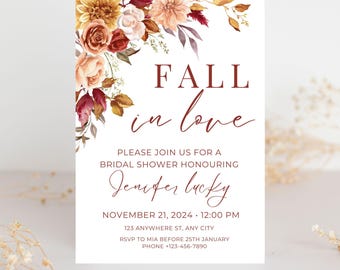 May include: A bridal shower invitation with the words "FALL in love" in burgundy script. The invitation includes details for Jennifer Lucky's shower, with a floral arrangement in the upper left corner. The flowers are in shades of orange, red, and white.