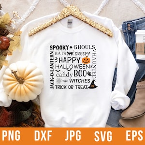 May include: White sweatshirt with a Halloween-themed graphic. The design includes the words "Spooky," "Happy Halloween," "Boo," and "Trick or Treat," along with bats, a pumpkin, and a witch's hat. The sweatshirt is displayed with jeans and a coffee cup.