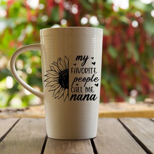 May include: White ceramic mug with a black sunflower design and the text "my favorite people call me nana".
