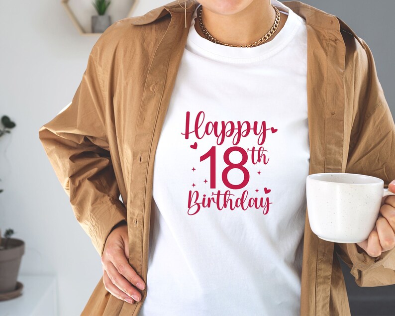 以下が含まれることがあります： 赤いハートと星がついた赤い文字で「Happy 18th Birthday」と書かれた白いTシャツです。