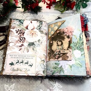 May include: Open journal with decorative pages. One page features a floral design with a quote about Christmas Eve. The opposite page has a vintage photo with the word "Joy". The journal is decorated with glitter and festive embellishments.