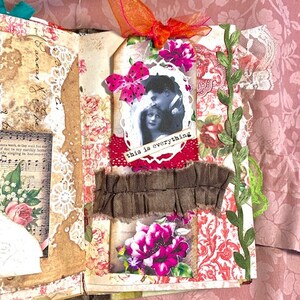 May include: Open scrapbook page with vintage floral and lace elements. Features a black and white photo with the text "this is everything". Embellished with pink flowers, a brown fabric strip, and an orange ribbon.