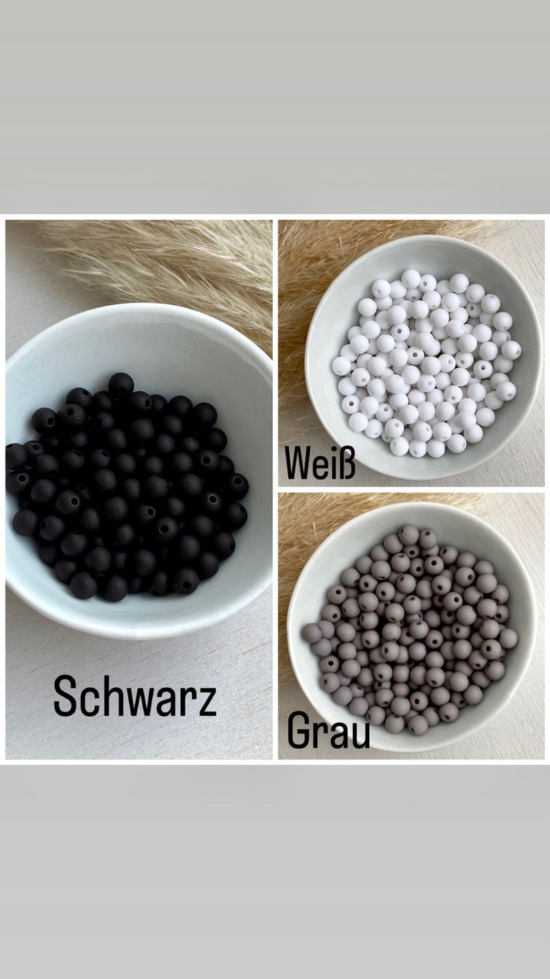Op de afbeelding: Drie kommen met zwarte, witte en grijze kralen. De zwarte kralen zijn gemarkeerd met "Schwarz", de witte kralen met "Wei&szlig;" en de grijze kralen met "Grau". De kralen zijn klein en rond.