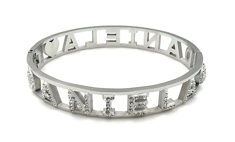 May include: Silver bangle bracelet with the word "VALENTINA" spelled out in cut-out letters. The letters are outlined with small, clear rhinestones.