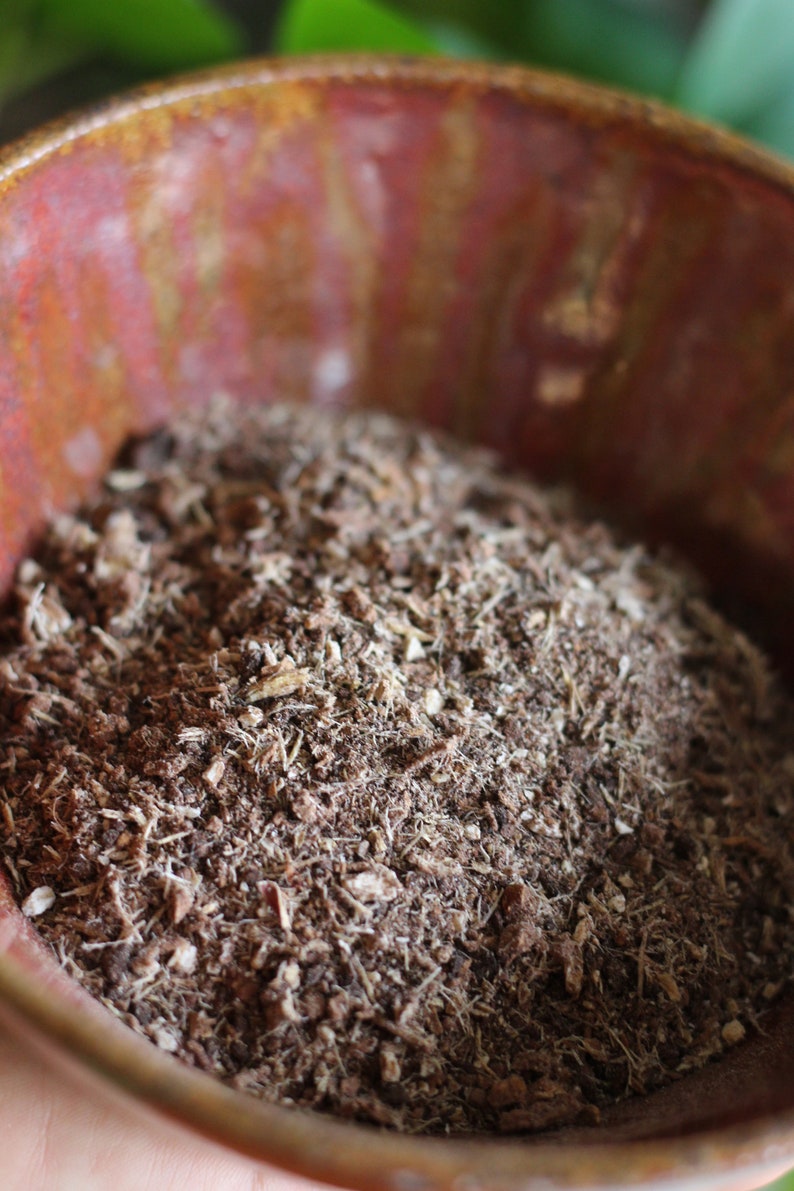 May include: A close-up of a terracotta pot filled with dark brown potting soil. The soil is loose and crumbly, with visible pieces of bark and wood.