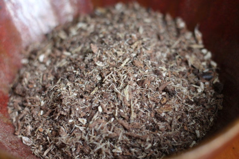 May include: Close-up of a brown and white soil mixture in a terracotta pot. The soil is made up of small pieces of bark, wood chips, and other organic matter.