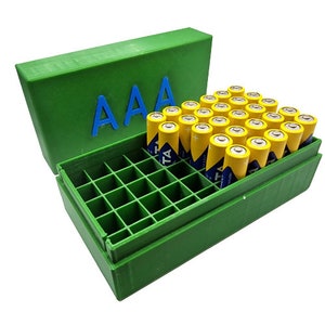 Könnte beinhalten: Grüne Plastik-Aufbewahrungsbox mit einem Deckel, der mit "AAA" beschriftet ist, und einem Gitter-Innenraum, der mehrere gelbe AAA-Batterien enthält.