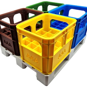 Könnte beinhalten: Vier Miniatur-Holzkisten, jede in einer anderen Farbe: Braun, Gelb, Grün und Blau. Die Kisten sind übereinander gestapelt und haben die Buchstaben "AAA" auf der Vorderseite aufgedruckt. Die Kisten stehen auf einer weißen Palette.