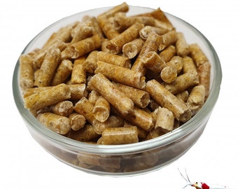 May include: A glass bowl filled with small, brown wood pellets. The pellets are used as a substrate for shrimp tanks.