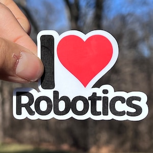 May include: A white sticker with black text that says "I love Robotics" and a red heart.