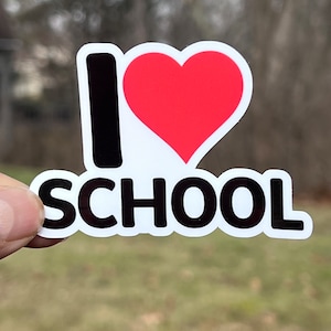 May include: A white sticker with black text that reads "I love school" with a red heart in place of the "o" in love.