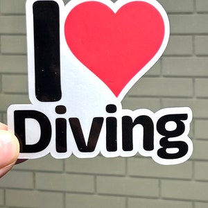 May include: A black and white sticker with a red heart and the text "I love Diving".