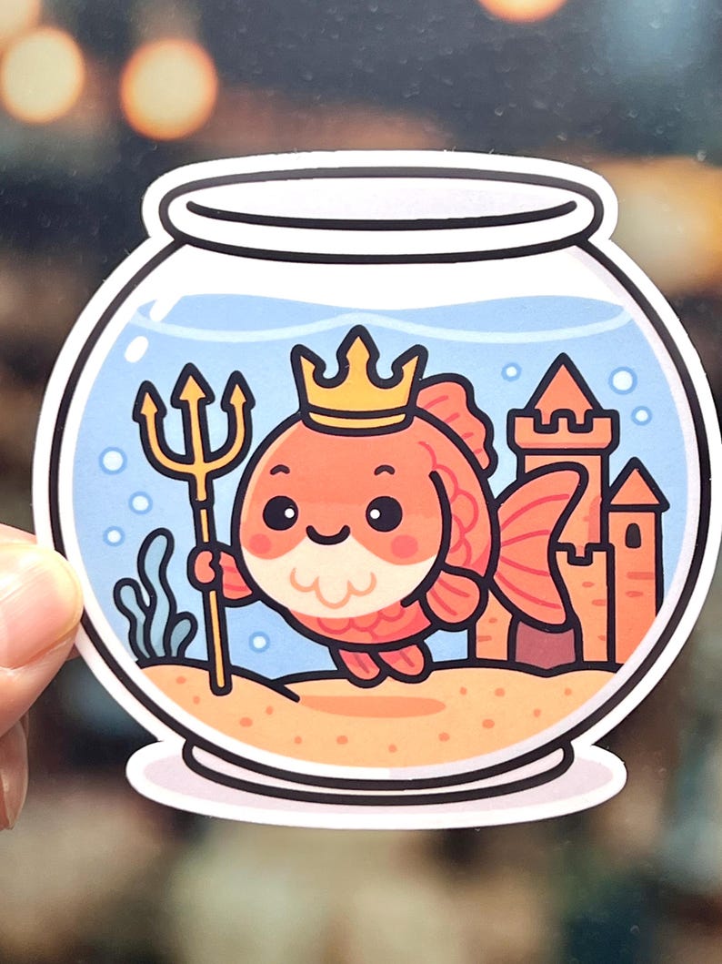 Kawaii goldfish sticker dressed as Poseidon with a crown and a golden trident. A waterproof, laminated vinyl decal shown on an aquarium stand or a laptop, perfect for mythology fans and fish owners