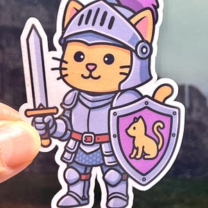 May include: A sticker featuring a cartoon cat in knight's armor, holding a sword and shield. The shield has a cat silhouette on a purple background. The cat wears a helmet with a purple plume. The armor is silver and the cat is orange.