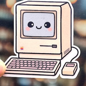 May include: A sticker featuring a vintage computer with a smiling face on the screen. The beige computer has a keyboard and mouse, with a small apple logo. The design has a cartoon style with pink accents.