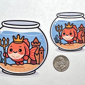 May include: Two stickers featuring a cartoon goldfish wearing a crown and holding a trident inside a fishbowl. The fishbowl has a castle and seaweed in the background. The goldfish is orange and the fishbowl is clear.