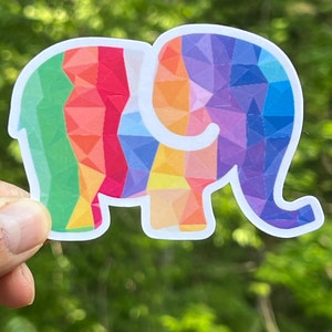 May include: A rainbow-colored elephant sticker with a geometric pattern. The sticker is made of vinyl and has a white outline.