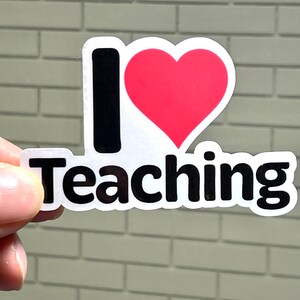 May include: A white sticker with black text that says "I love teaching" and a red heart.