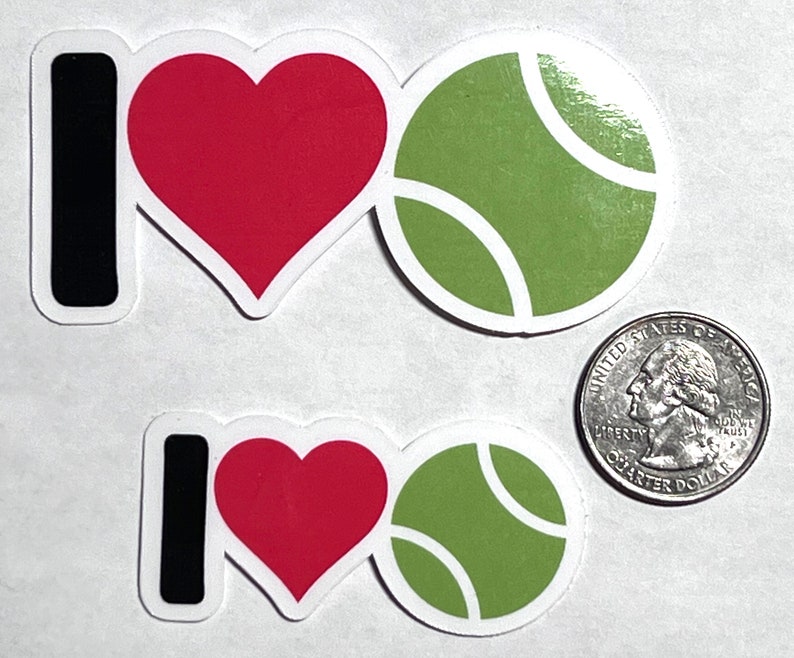 May include: Two stickers with the phrase "I love tennis." The "I" is black, the heart is red, and the tennis ball is green with white curved lines. A U.S. quarter is included for size comparison.