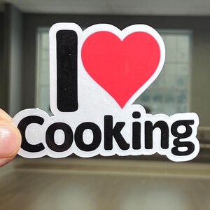 May include: A white sticker with black text that says "I love Cooking" and a red heart.