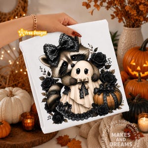 May include: A white fabric sheet featuring a graphic illustration of a raccoon wearing a black lace bow, hugging a small ghost figure. The design includes black roses, a pumpkin wrapped in black lace, and decorative black lace accents throughout.