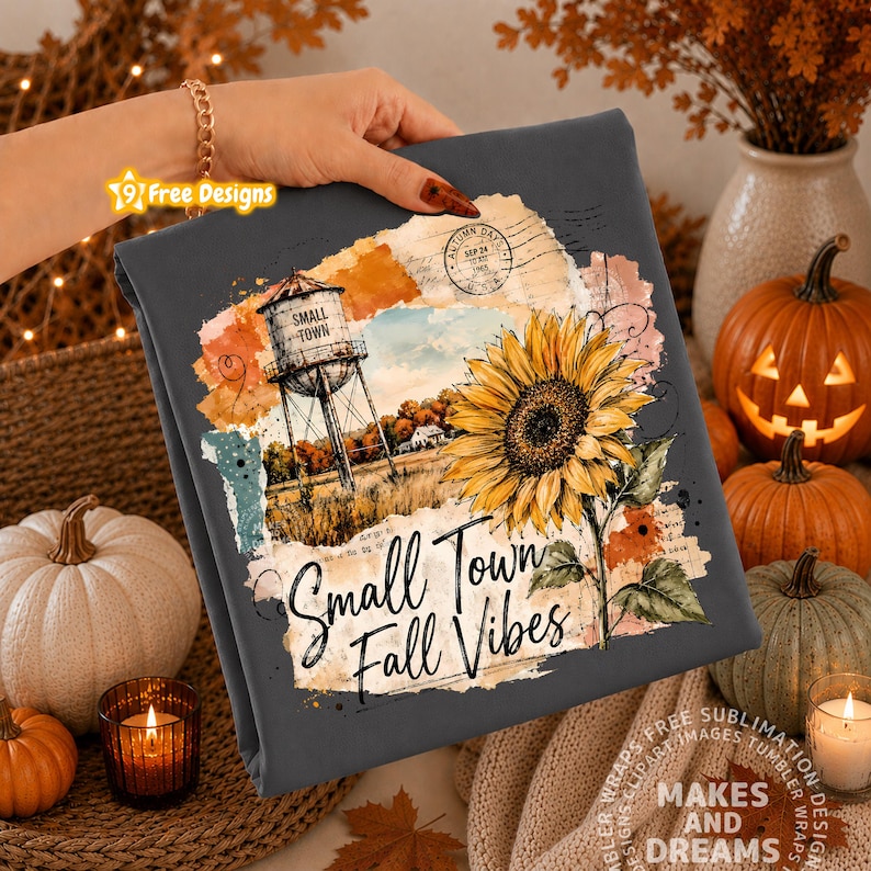 May include: A dark gray fabric featuring a graphic print of a water tower, a large yellow sunflower, and vintage paper textures. The text reads Small Town Fall Vibes in a black script font. The design includes a circular postmark stamp.